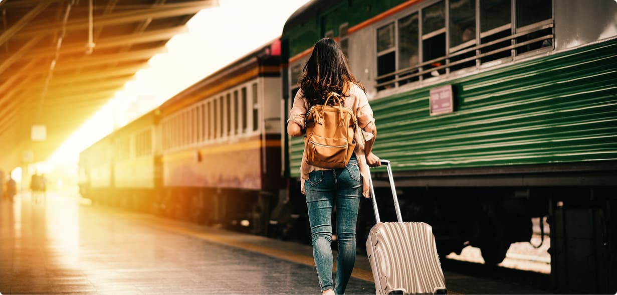 Viaggiatrice solitaria con zaino su un binario della stazione